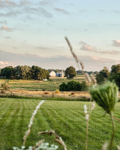Sunset over rolling Ohio fields with barn and silos in the distance