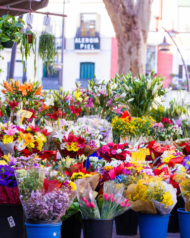 Colourful flower bouquets in buckets at a rural market stall