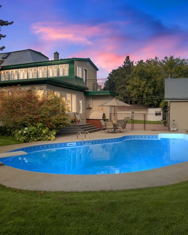 Large house with outdoor pool and green lawn